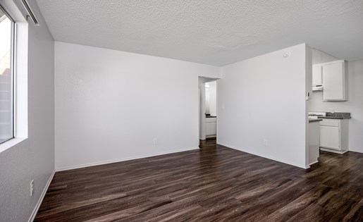 A room with wooden flooring and white walls.